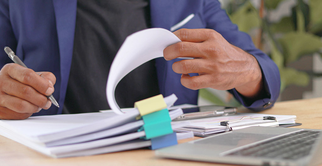 Bureau professionnel avec documents de traçabilité des déchets, bordereaux de suivi et formulaires de conformité réglementaire organisés sur un plan de travail